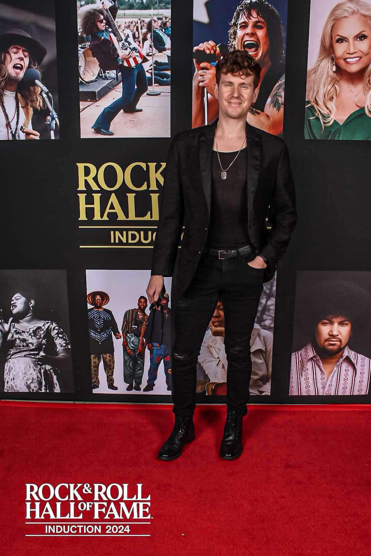 Geordie Brown stands on a red carpet at the Rock & Roll Hall of Fame.